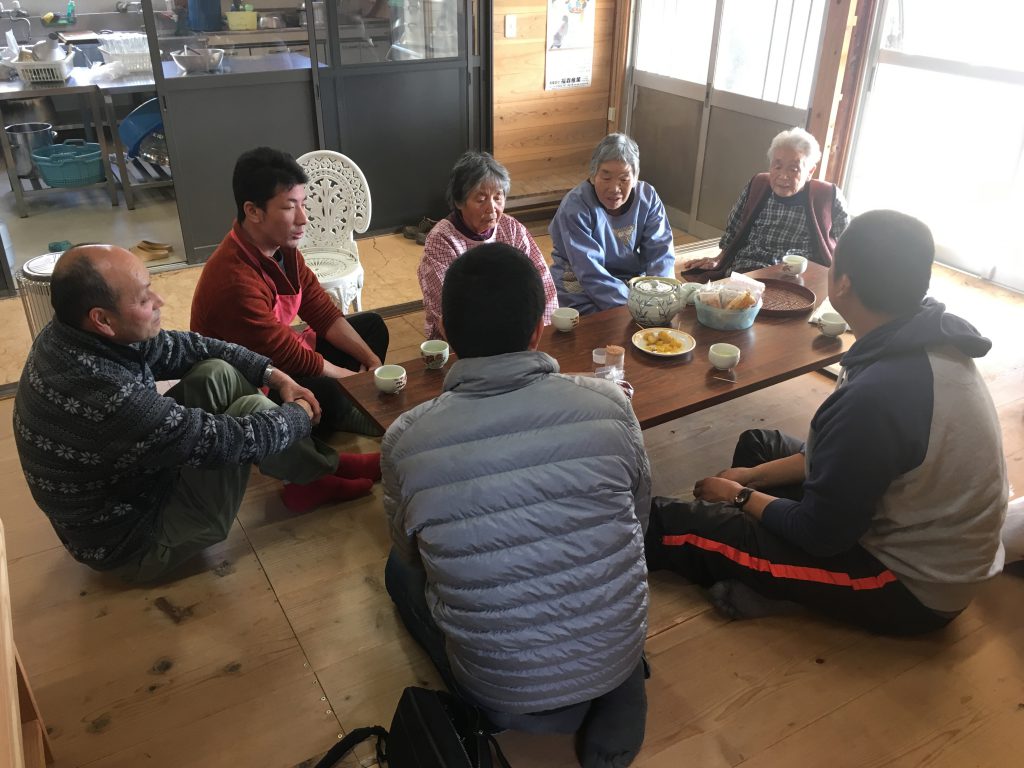 People sitting around a table. The half of them is elderly