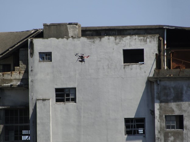 Drone flying in front of a white deserted building