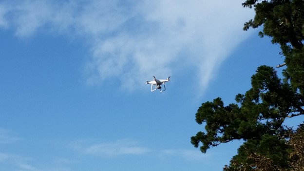 White drone flying in a blue sky