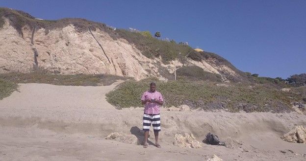 Man on a beach holding controllers