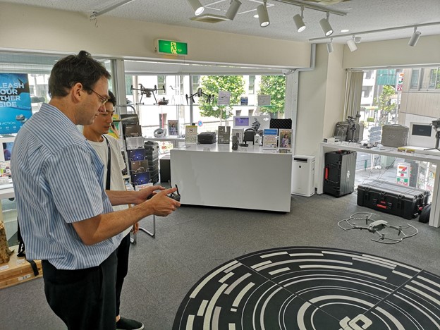 David flying a small drone at the DJI store