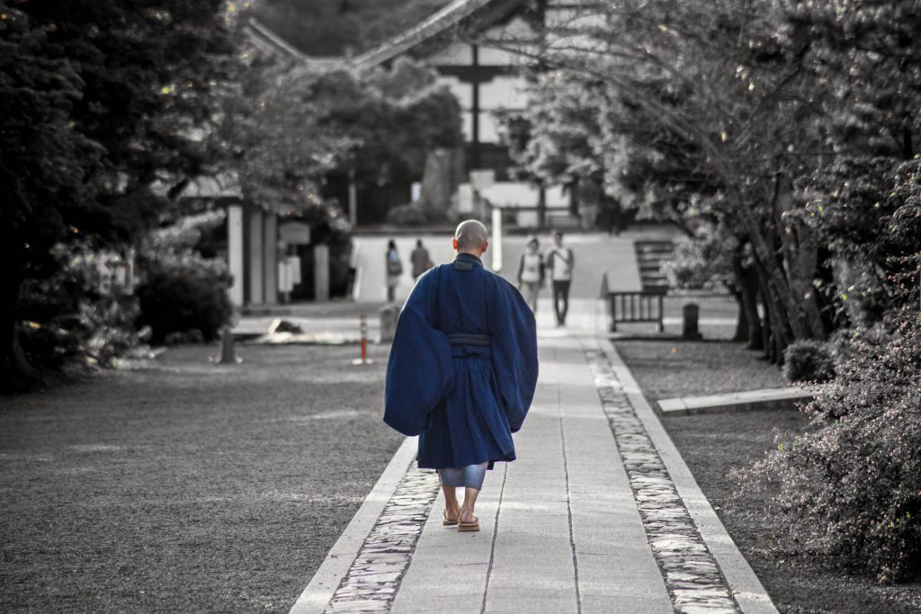 Japanese monk walking near a temple