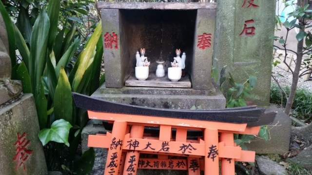 A small altar in which two small white foxes statues can be seen