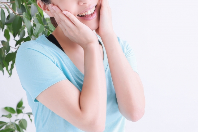 Japanese woman smiling naively with her hands on her cheeks