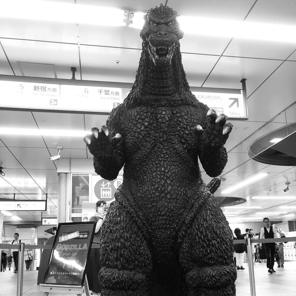 Human-sized Godzilla statue in a station