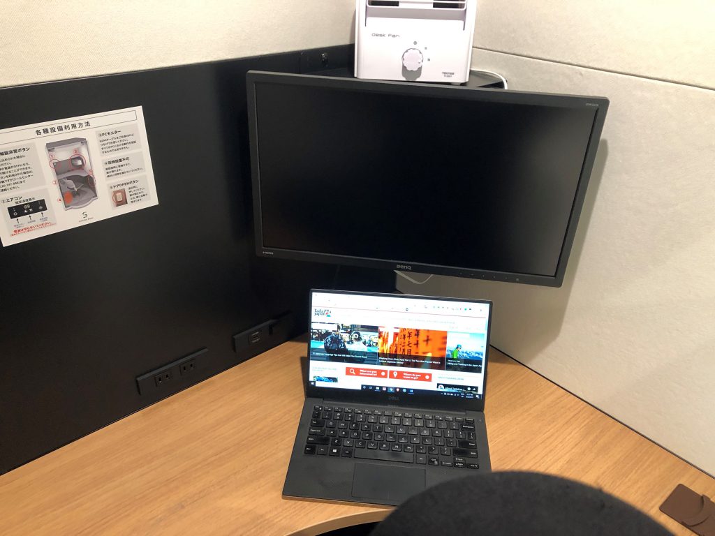 A table with a portable laptop and a screen