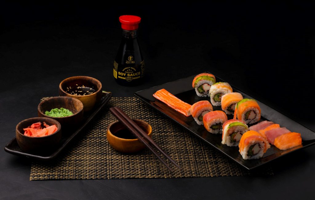 A bottle of soy sauce, sushis and chopsticks