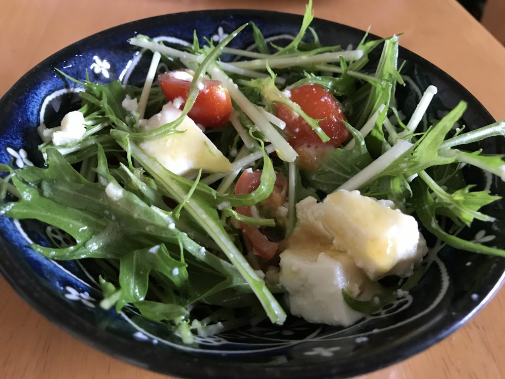 A simple salad with tomatoes, greens and tofu.