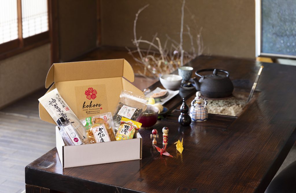 A cardboard box is full with Japanese food packages. 