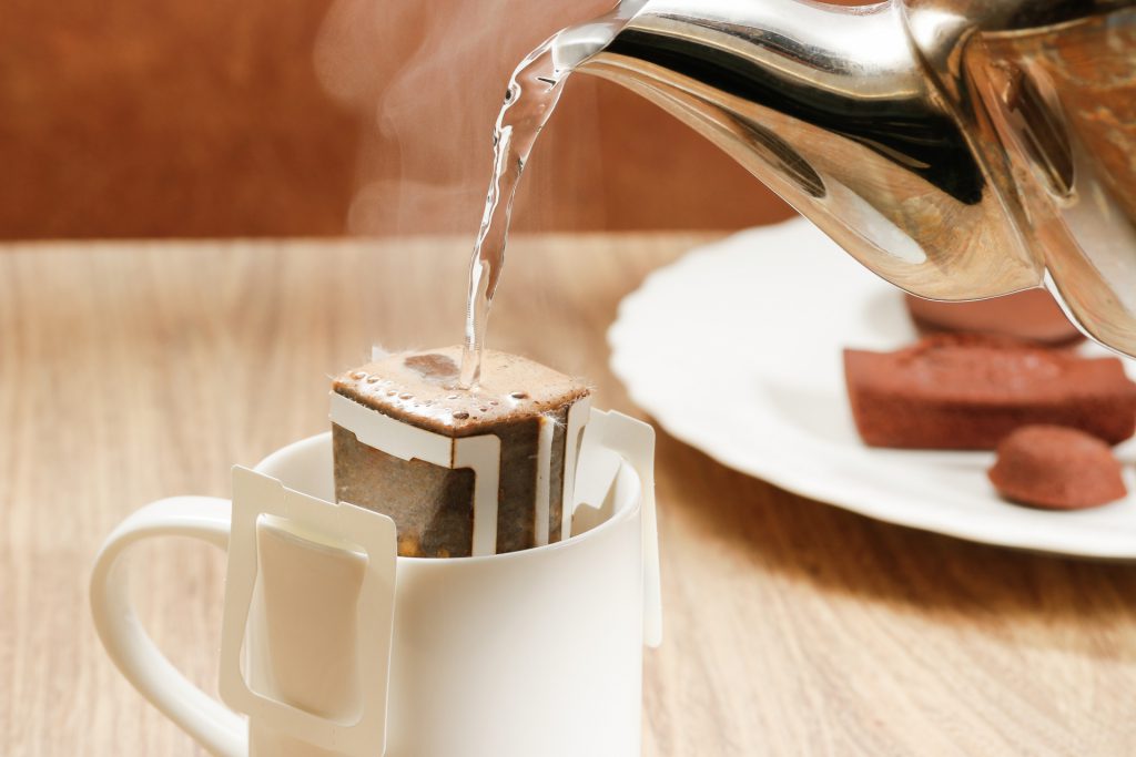 Water is poured on a coffee bag on top of a cup