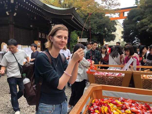 Amelie is "fishing" a fish-shaped oracle at a Japanese shrine