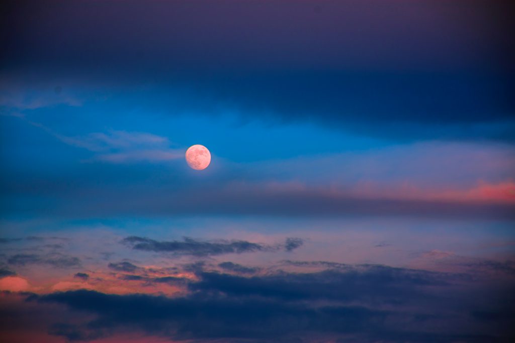 A pink full moon at dusk
