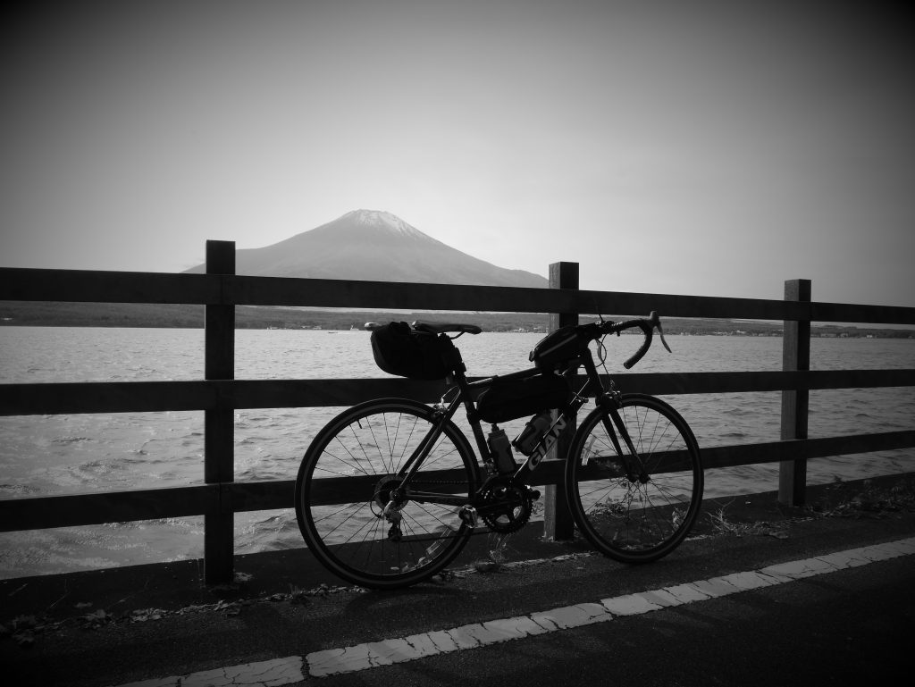 A bicycle in front of a lake. In the back, Mount Fuji.