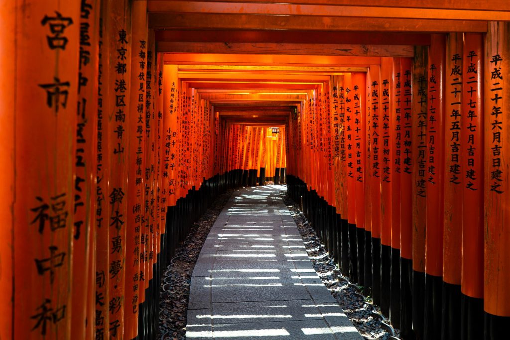 Vermillon torii gates with kanji written on them