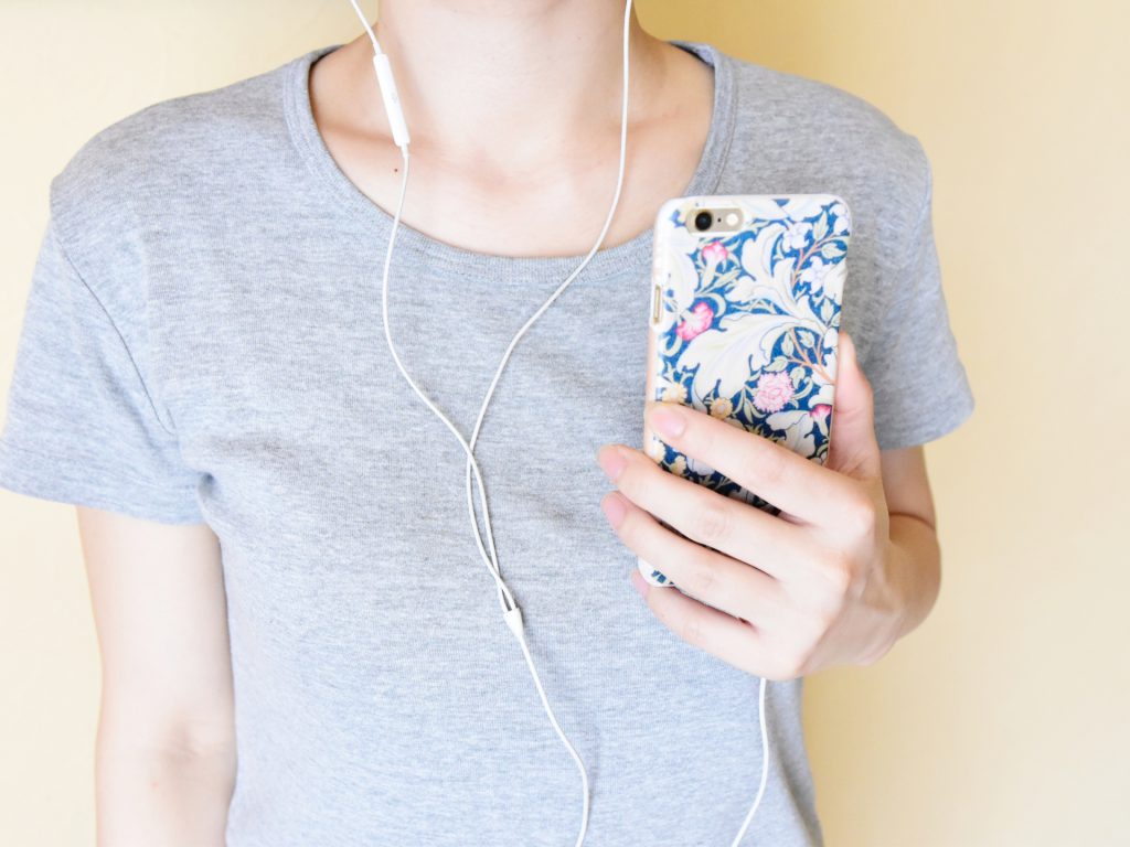 A woman with earphones linked to her smartphone