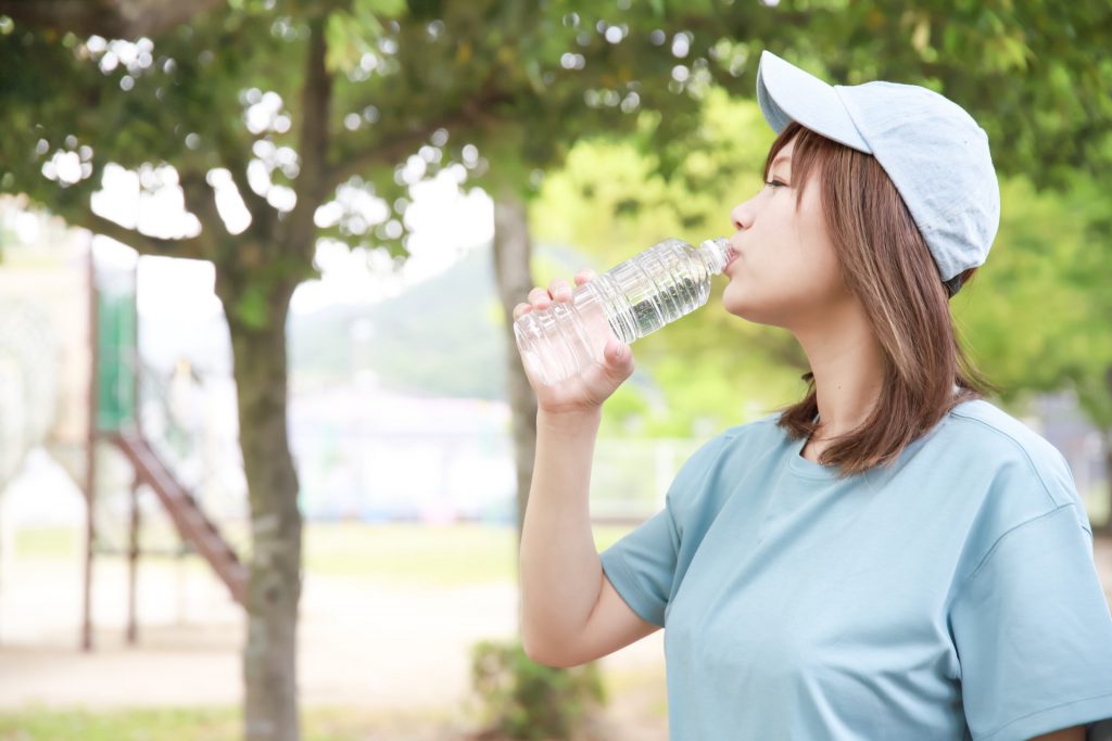 A Japanese woman is drinking a bottle of water