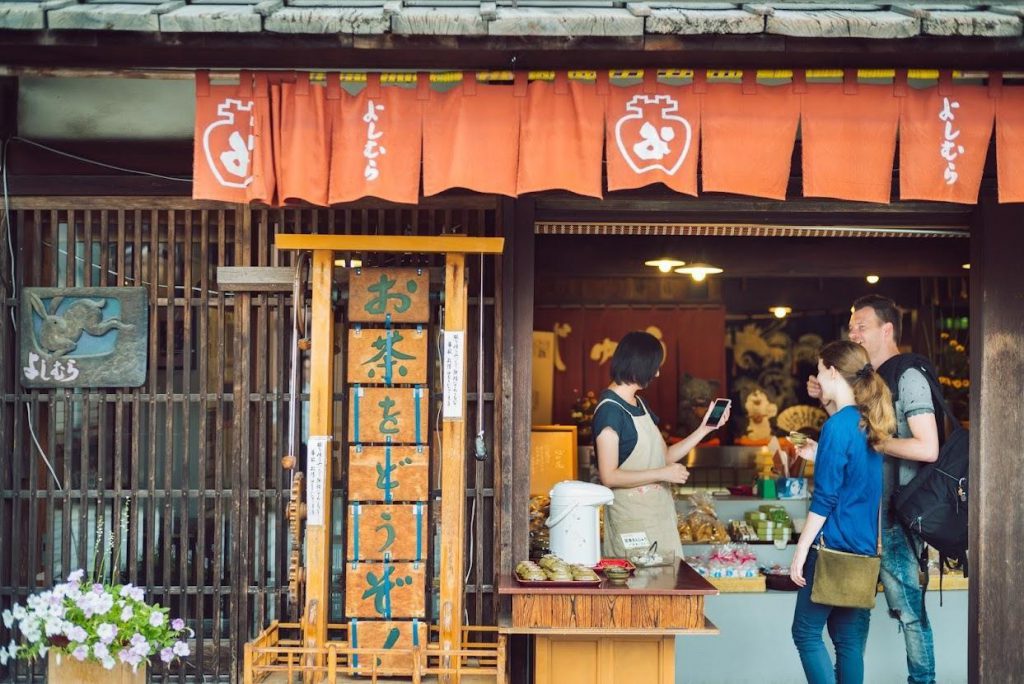 A Western couple is shopping at an Inami sweets shop.