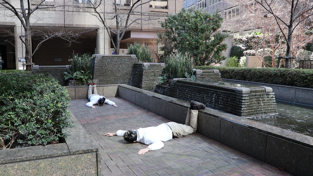 KEKE and Aisa lying on the floor with their feet on top of small walls.