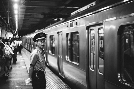 A station employee is waiting on a train platform