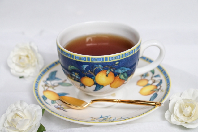 A fancy, English-style teacup surrounded by white flowers.