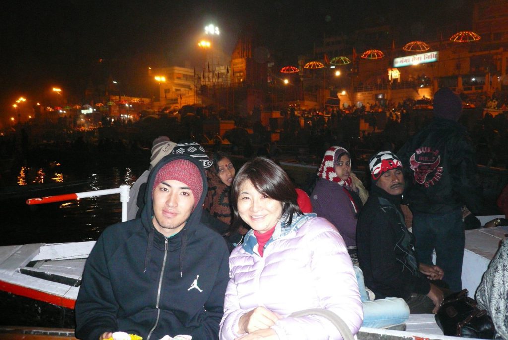 Manabu Goto and his mother sitting on a boat and smiling at the camera