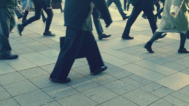The picture shows legs of workers in suits walking in Tokyo