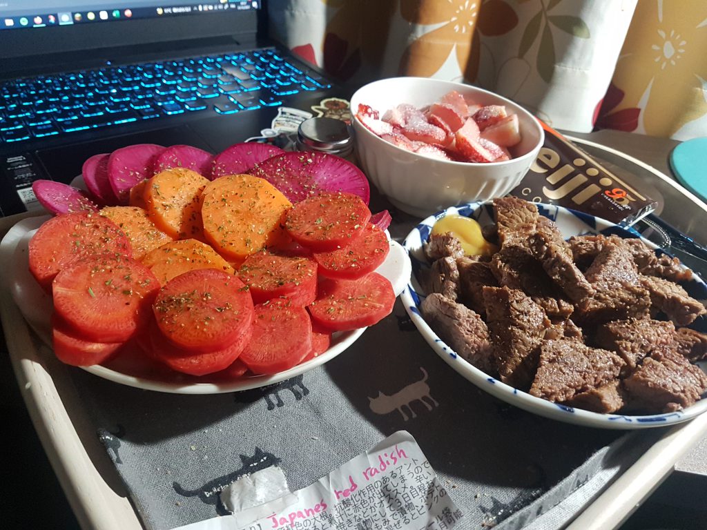 Sliced carrots and red radish, daikon and meet in small dishes