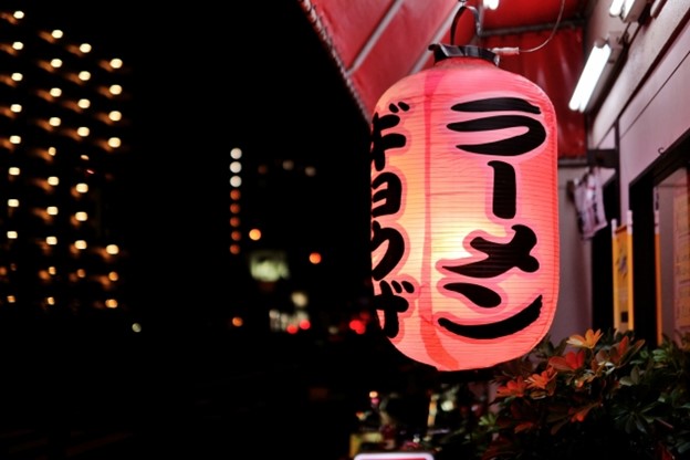 A red lantern for a Japanese restaurant has the words "gyoza" and "ramen" written in katakana on it.