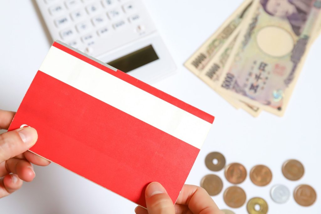 A Japanese cashbook, Japanese banknotes, coins, and a calculator.