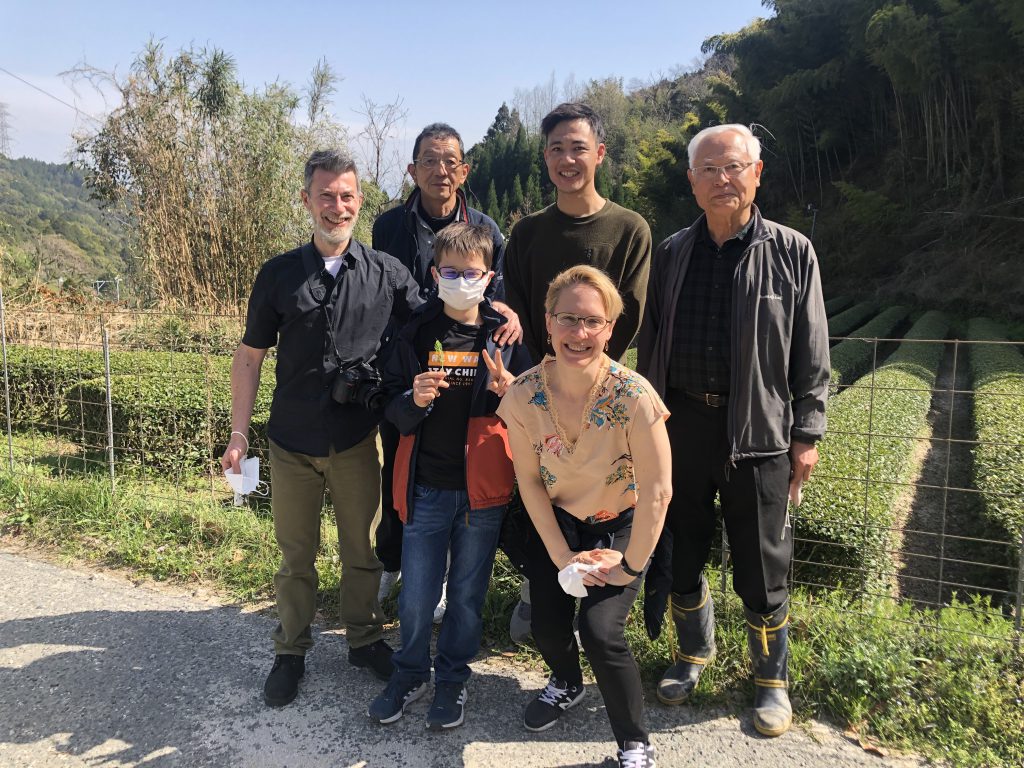 Aldo, Joelle and their son are standing next to three generations of producers. All are smiling.