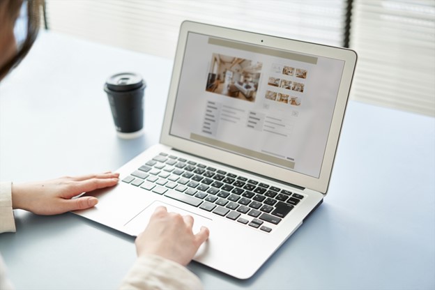 Someone is doing research on their computer. The screen shows pictures of apartments.