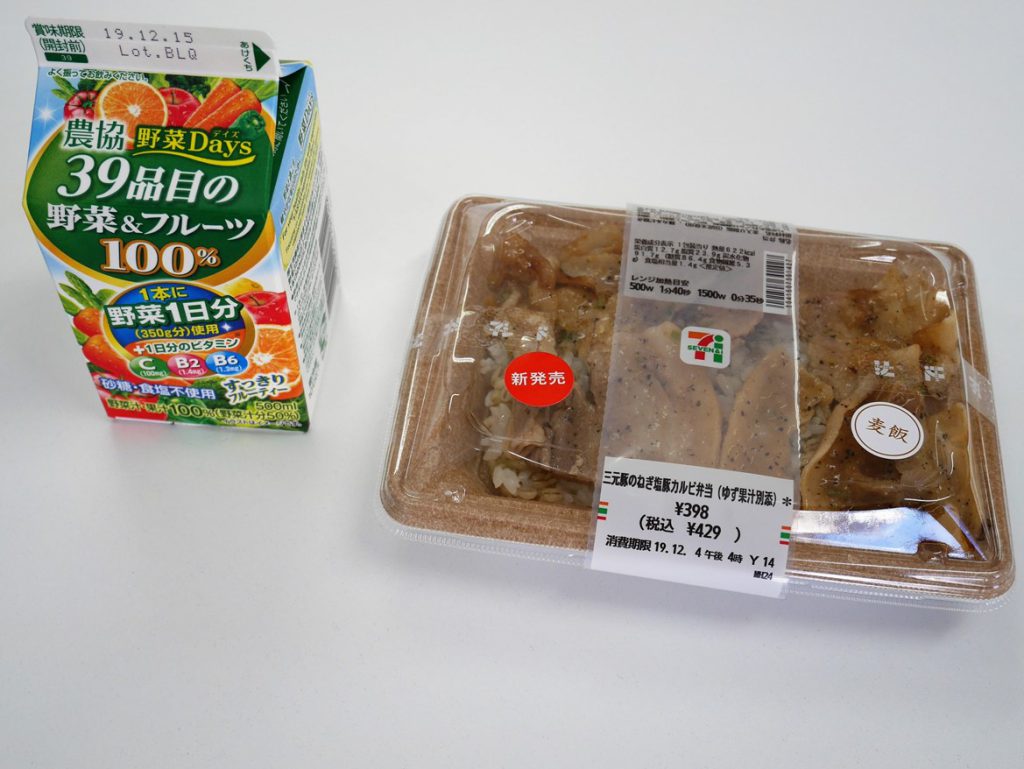 A pack of vegetable juice and a bento of roasted pork