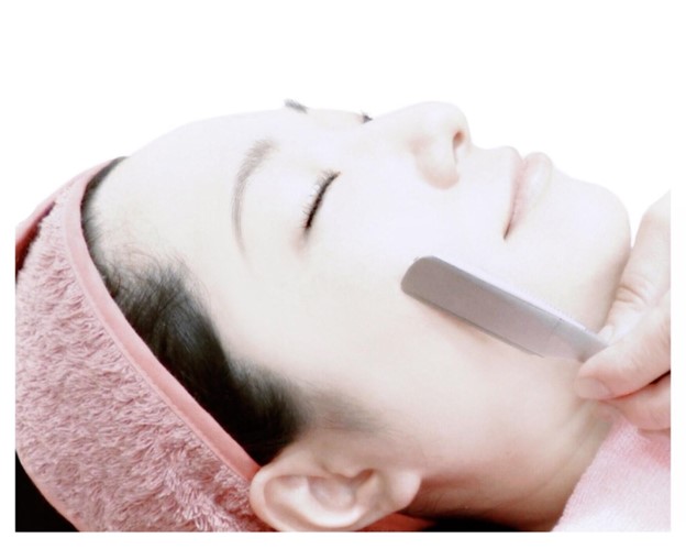 A Japanese woman is getting her face shaved,