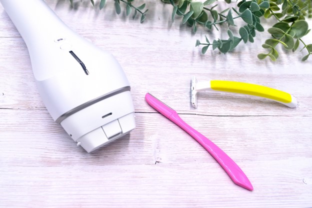 An electric razor and two hand razors on a table