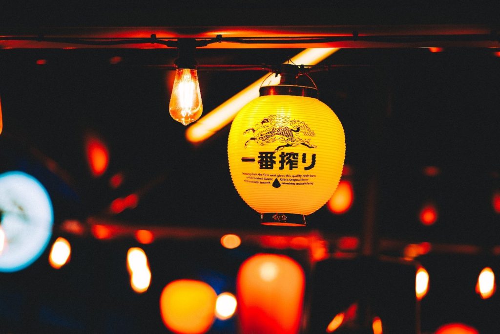 A yellow lantern in an Izakaya on which the logo of a Japanese beer brand can be seen