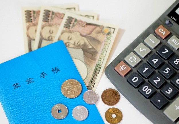 The Japanese pension blue booklet, Japanese cash money and a calculator.