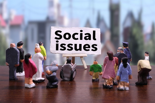 Clay characters representing people of all ages, genders, jobs, and abilities gather around a sign saying "Social Issues"